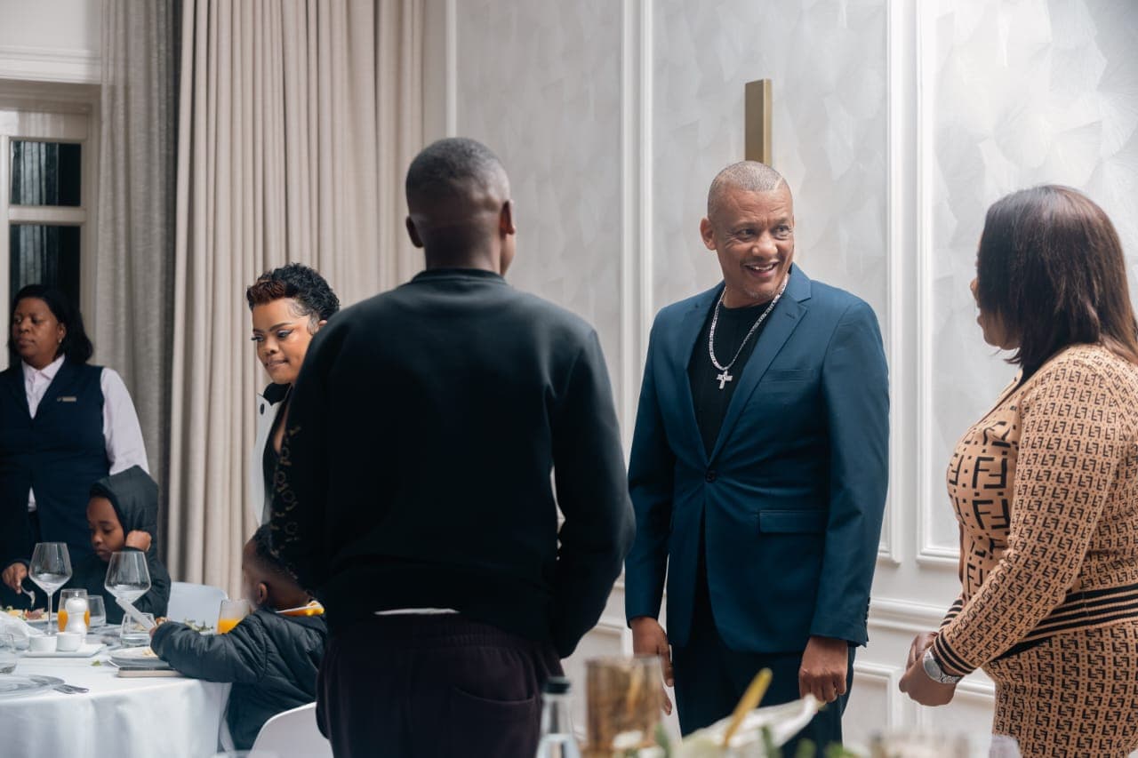Dr. Keith Clint Harrington in conversation with guests at the Principal Princess's birthday party